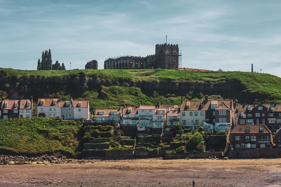 Beautiful view of Whitby Abbey with houses below in a picturesque coastal town setting.